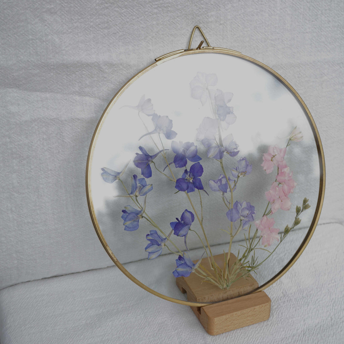 Delphinium en marco de latón redondo