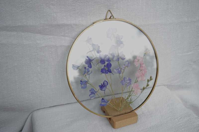 Delphinium en marco de latón redondo